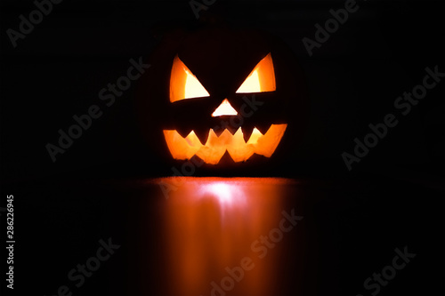 Wallpaper Mural Halloween October holiday celebration symbol, scary pumpkin glowing with reflection, black background Torontodigital.ca