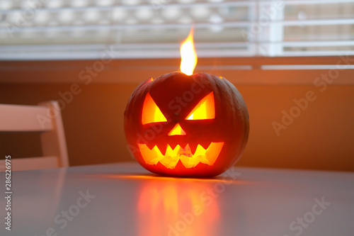Wallpaper Mural Halloween October holiday celebration symbol, scary pumpkin on kitchen table glowing from inside Torontodigital.ca