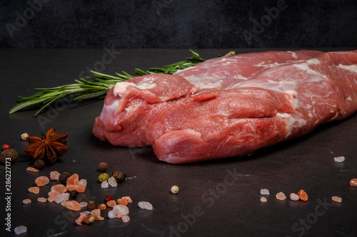 closeup two long pieces of raw marbled meat with rosemary