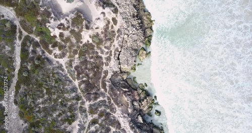 Wallpaper Mural Vertical aerial view of flight along coast with wild ocean surf, beach, turquoise water and beautiful changing textures in slow motion as background or backdrop with copy space. Torontodigital.ca