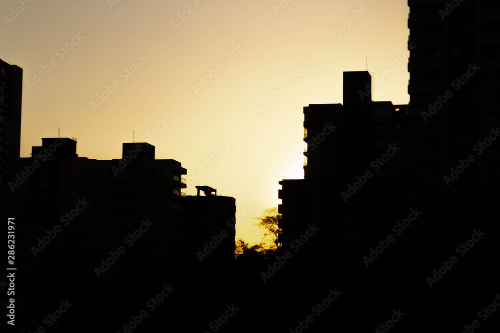 Sun setting behind buildings in Ribeirão Preto