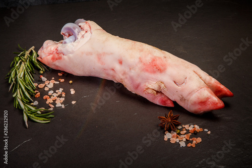 top view on large raw pork leg with hoof with rosemary