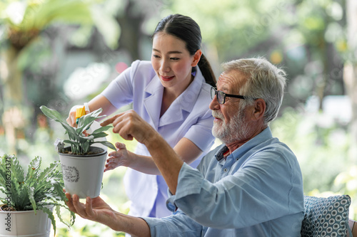 Canvas Print Senior man taking care of his plants with nurse