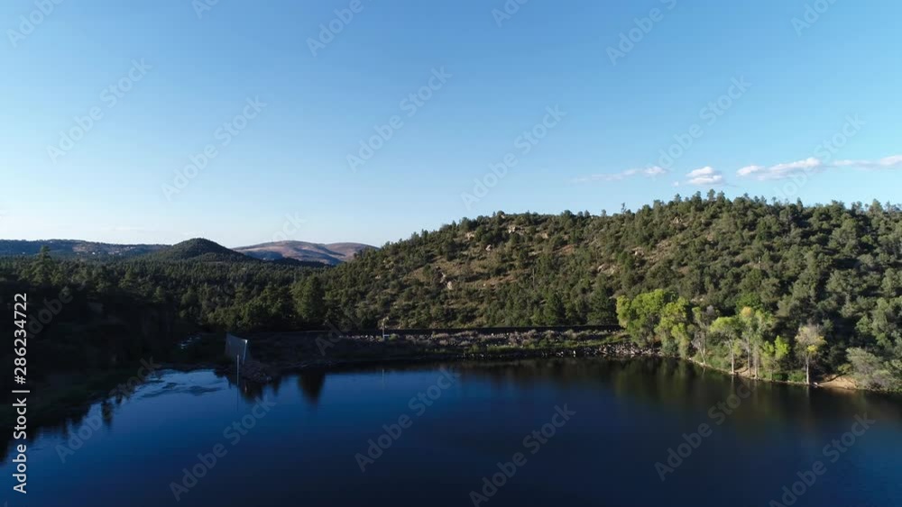 Epic Mountain Landscape over Scenic Lake with Deep Blue Sky and Manmade Dam Epic Mountain Landscape over Scenic Lake with Deep Blue Sky and Manmade Dam