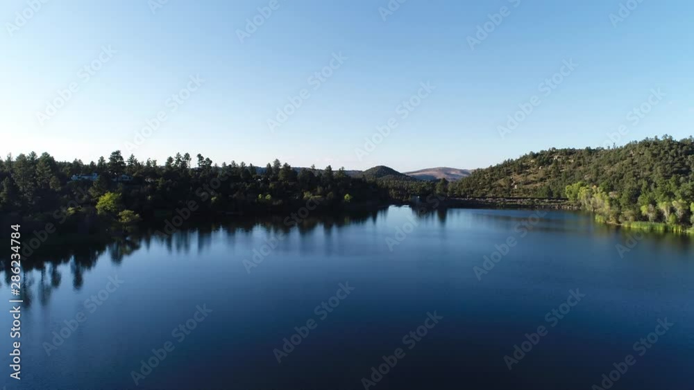 Panning Shot Over Scenic Mountain Spring Valley Lake with Hilly Surroundings