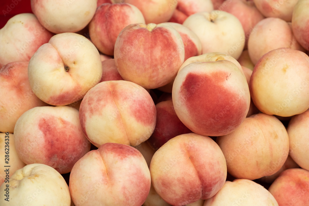 A pile of bright red peach collected from the tree Prepare to be released for sale to customers. That are healthy and eaten. fruit background. A pile of bright red peach collected from the tree Prepare to be released for sale to customers. That are healthy and eaten. fruit background.
