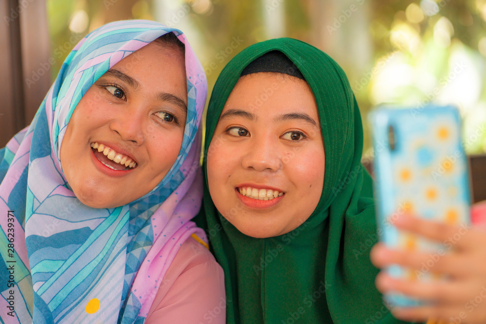 Muslim teenager student girlfriends selfie - pretty Asian Indonesian girls  in traditional Islamic hijab head scarf taking selfie together Stock-Foto |  Adobe Stock