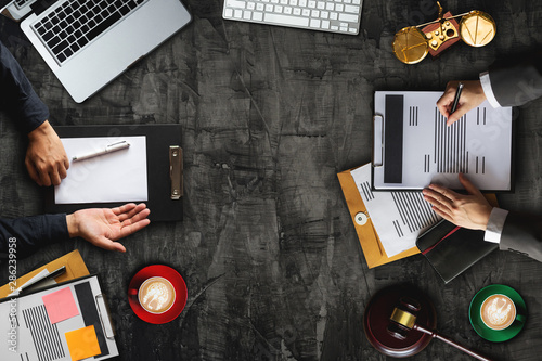 Foto top view Business and lawyers discussing contract papers with brass scale on desk in office