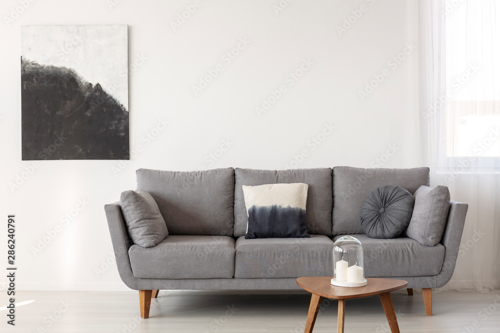 Plakat Grey scandinavian sofa in bright living room interior