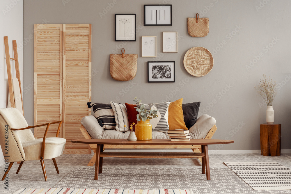 Trendy creme colored armchair in Scandinavian living room interior with  gallery of posters on beige wall Stock Photo | Adobe Stock