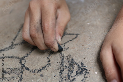 kid drawing with charcoal