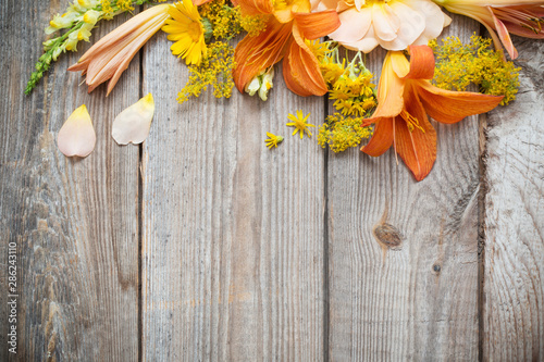 yellow and orange flowers on old wooden background