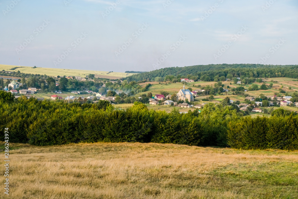 Ukrainian village of Porokhova in the valley between the hills. Sunset panorama. Copy space.