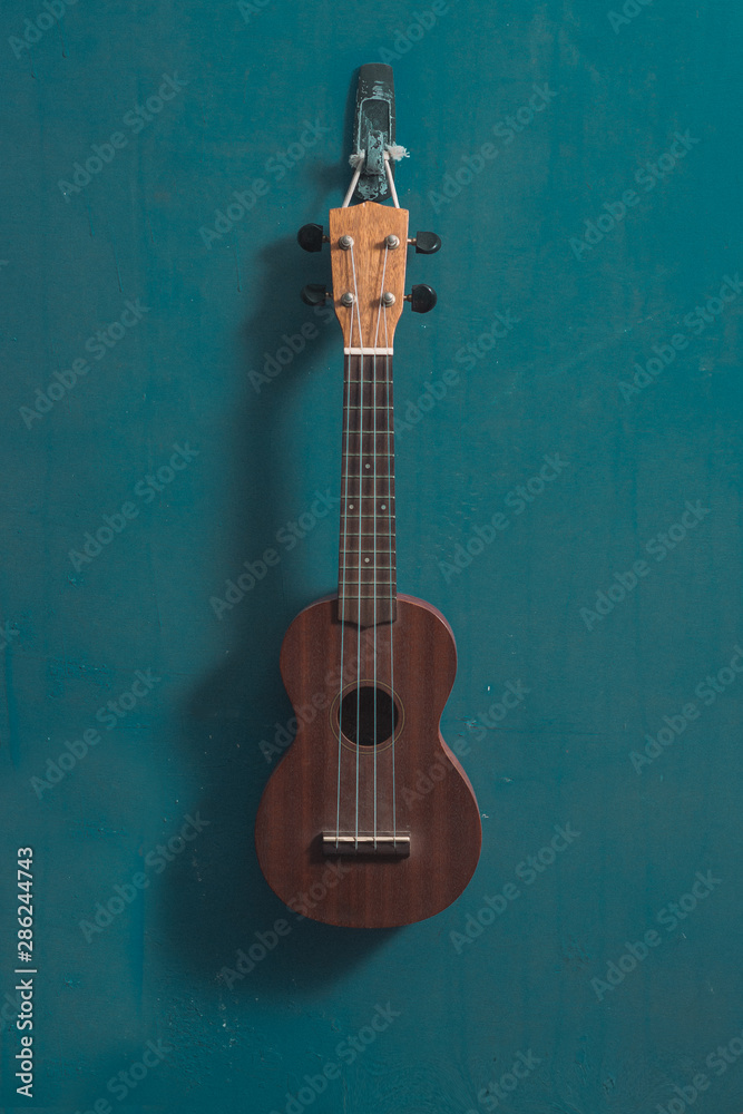 Naklejka premium ukulele in front view with isolated blue background