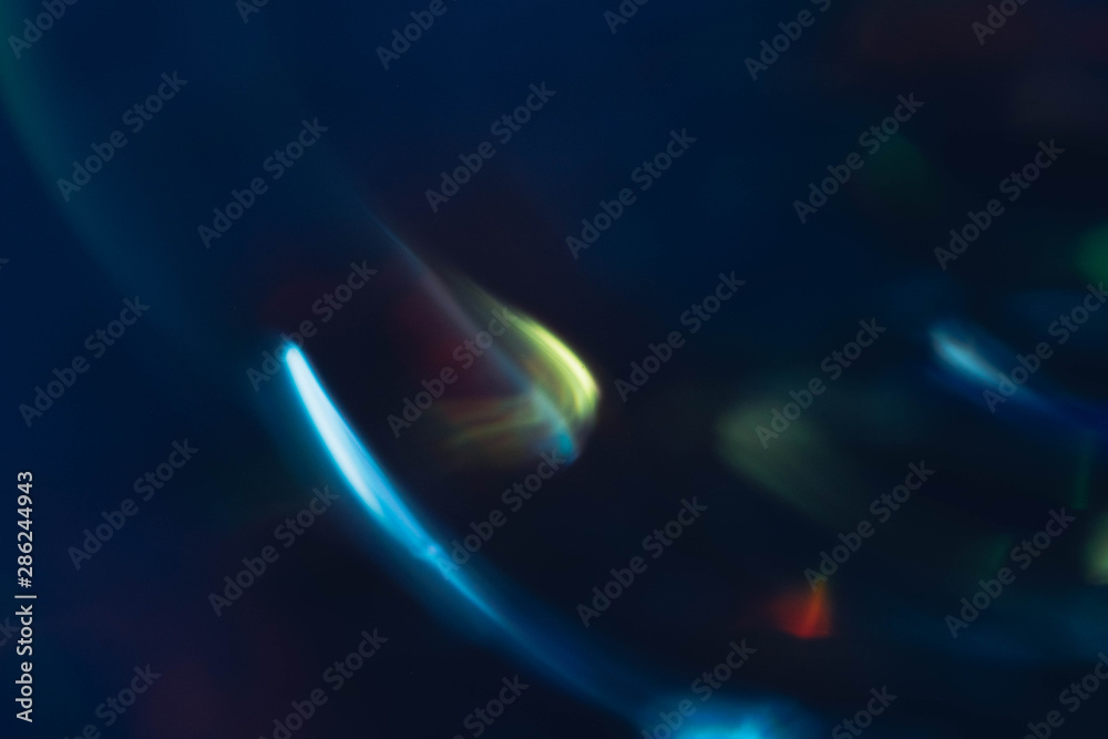 Blue and yellow bokeh lights. Blur glowing lines. Lens flare. Dark abstract background.