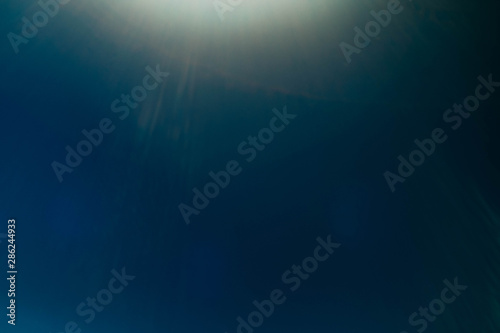 Blur light rays. Teal blue abstract art background. Lens flare glow. Sunlight effect.