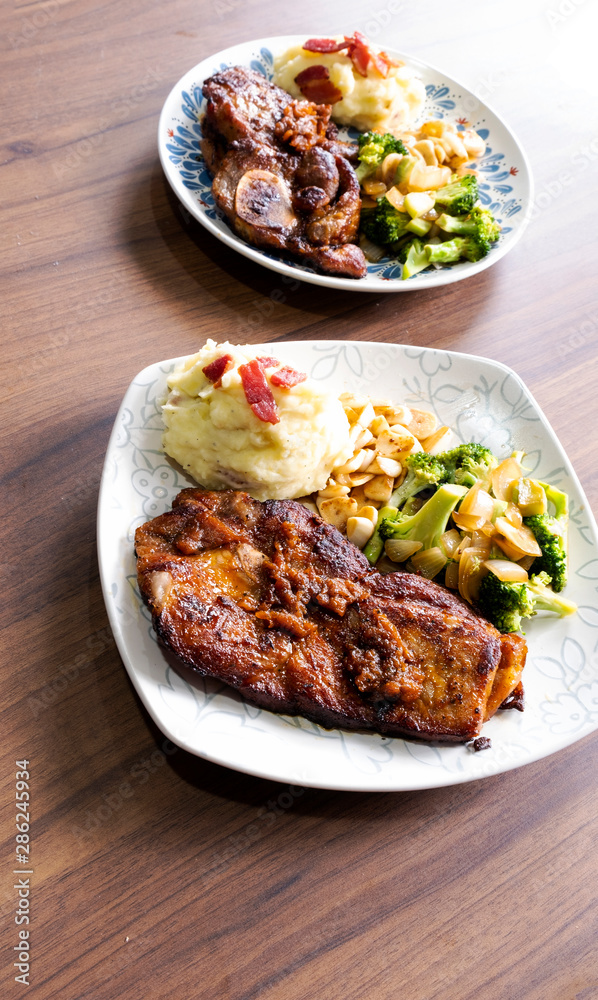 Pork steak with vegetables on a wood background Pork steak with vegetables on a wood background