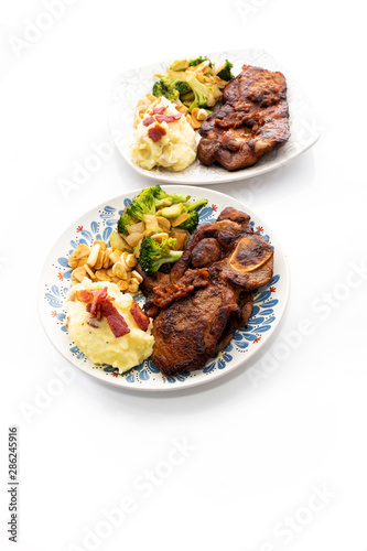 Pork steak with vegetables on a white background