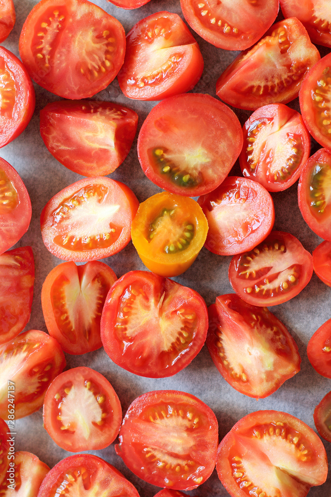 many red tomato slices on baking paper top view. cooking vegetables many red tomato slices on baking paper top view. cooking vegetables