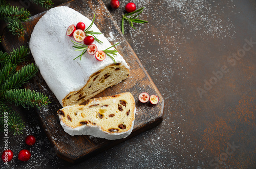 Christmas Stollen. Traditional German, European Festive Dessert. Holiday Concept Decorated with Fir Branches and Cranberries. photo