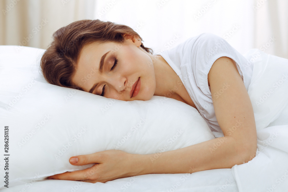Beautiful young woman sleeping while lying in her bed. Concept of pleasant and rest reinstatement for active life Beautiful young woman sleeping while lying in her bed. Concept of pleasant and rest reinstatement for active life