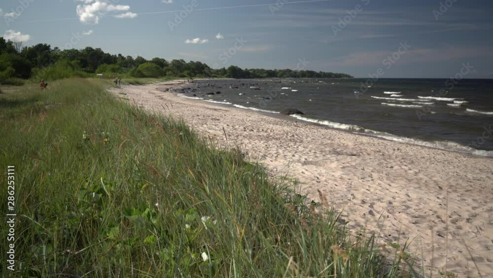 Surf waves roll on the sandy beach of the Baltic Sea in summer Surf waves roll on the sandy beach of the Baltic Sea in summer
