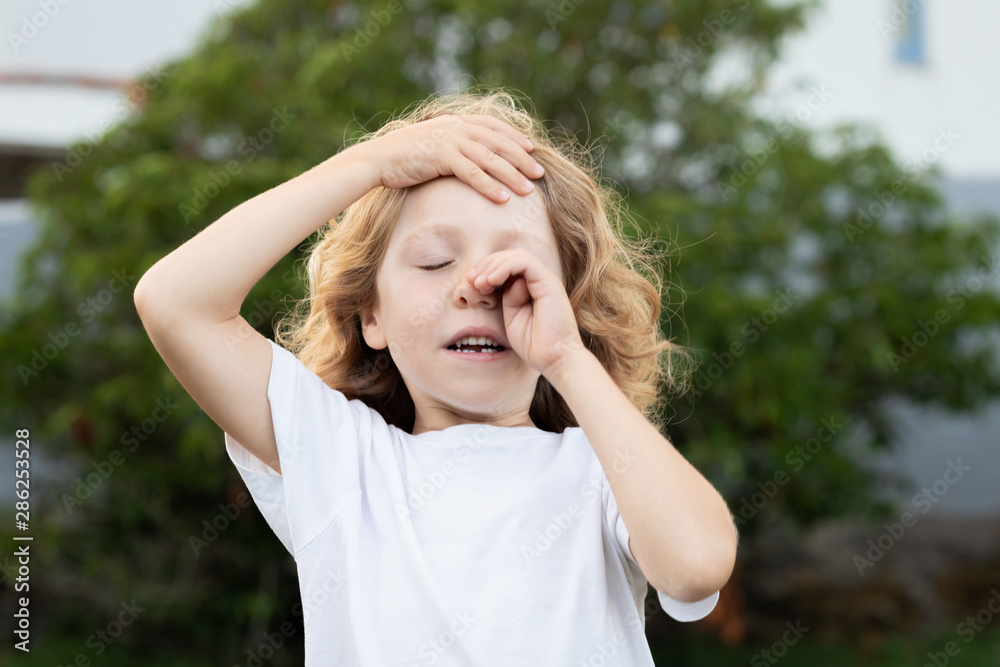 Blond child covering his eyes Blond child covering his eyes