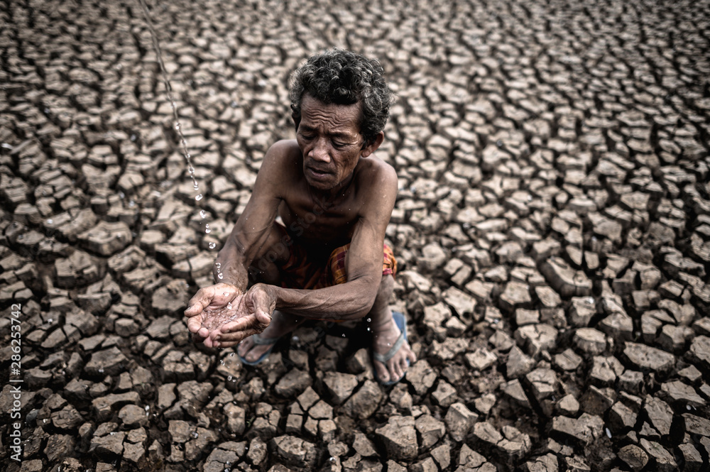 An elderly man sitting in touch with rain in the dry season, global warming, selection focus