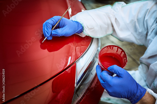 Tinting defects of a red car paint on the service photo