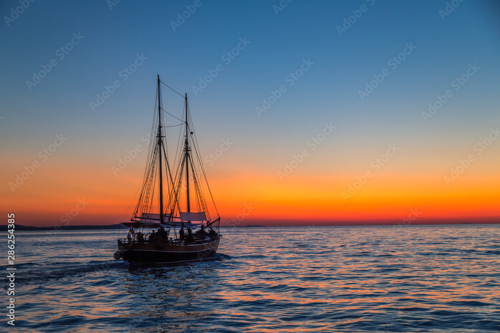 Sunset with silhouette of sailboat on the Adriatic sea near Zadar town, Croatia, Europe.