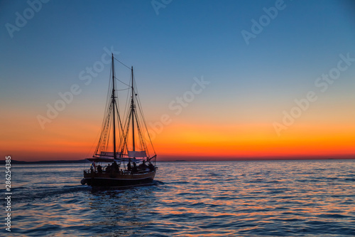 Sunset with silhouette of sailboat on the Adriatic sea near Zadar town, Croatia, Europe.
