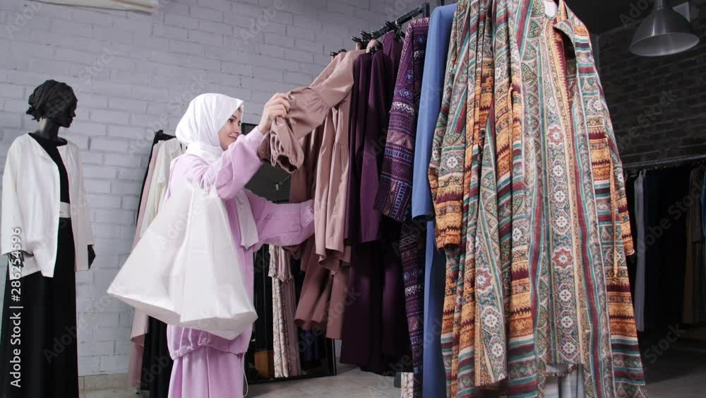 A young Muslim woman choosing clothes at the store A young Muslim woman choosing clothes at the store