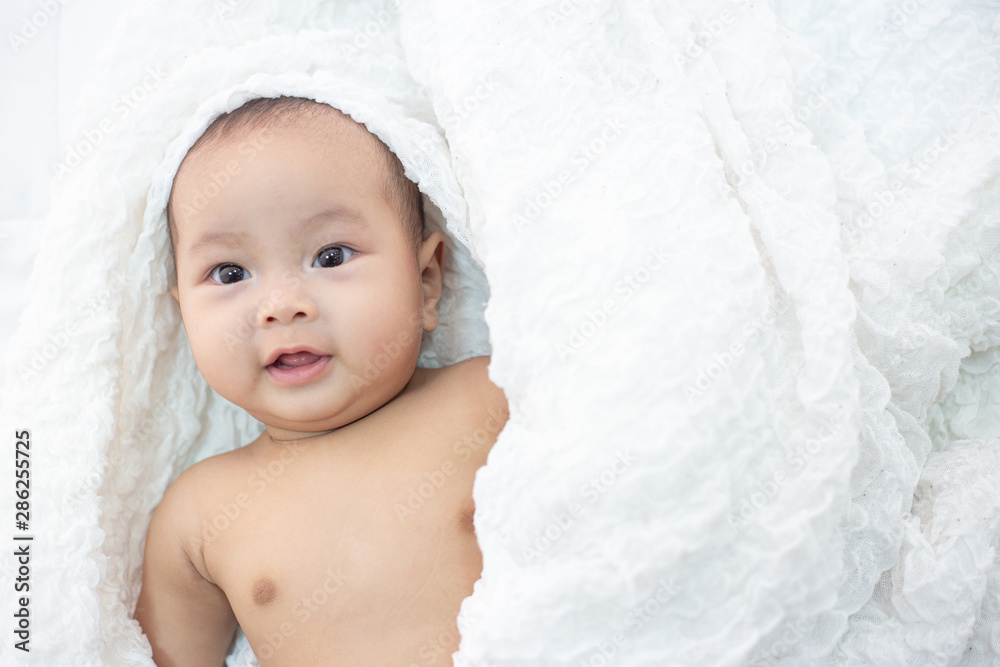 The baby is happy on the bed. The baby is happy on the bed.
