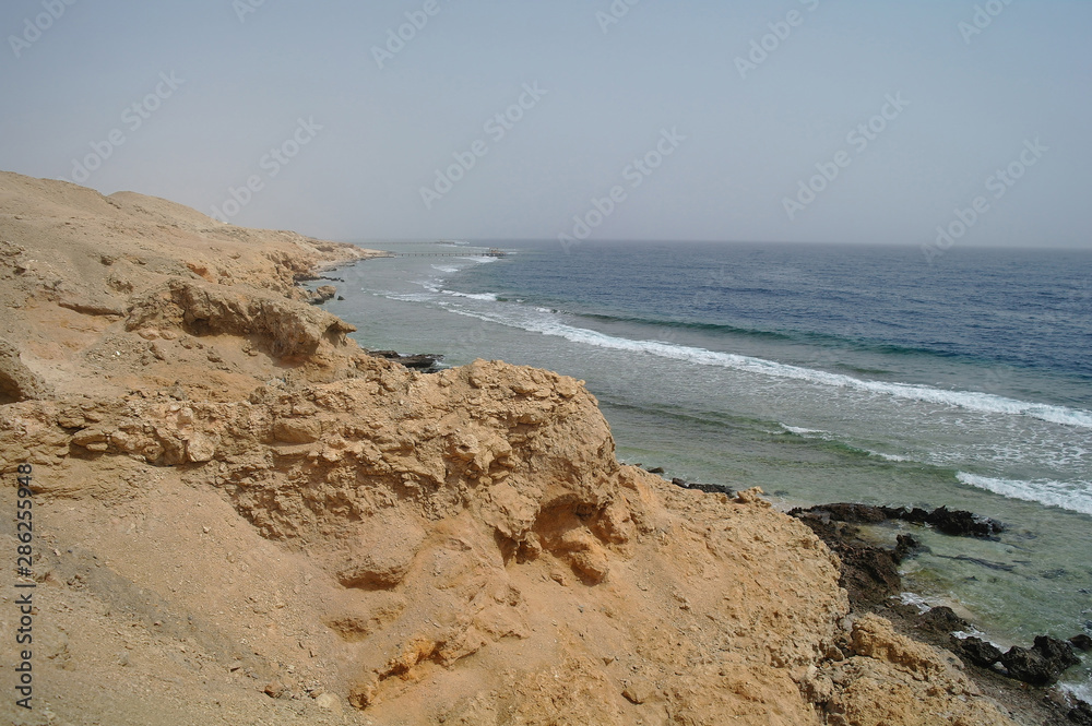 Beautiful azure red sea with waves and rocks and clear blue sky in Egypt