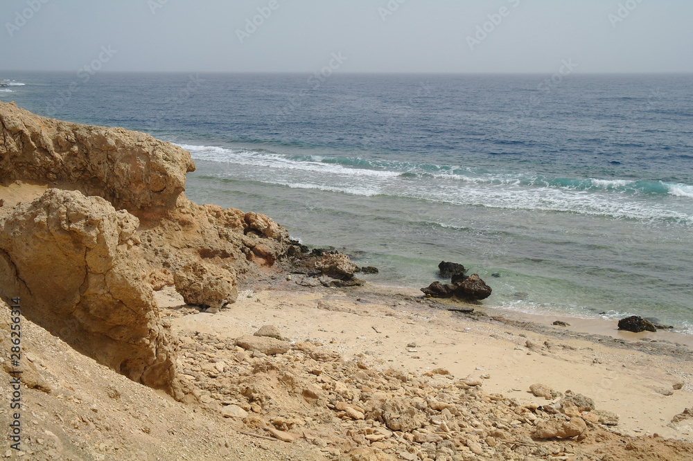 Beautiful azure red sea with waves and rocks and clear blue sky in Egypt