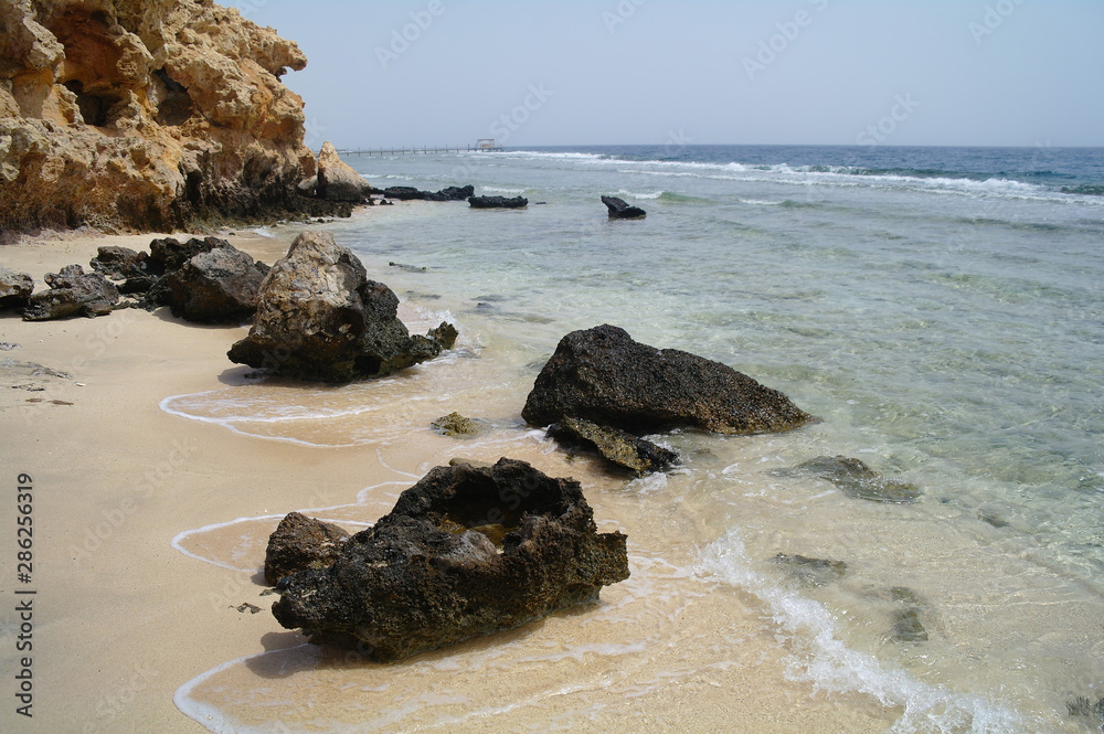 Beautiful azure red sea with waves and rocks and clear blue sky in Egypt