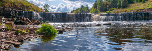 Panorama of waterfall on mountain river on summer day photo
