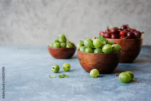 Variety of organic fresh gooseberries in bowl on the table. Close up view