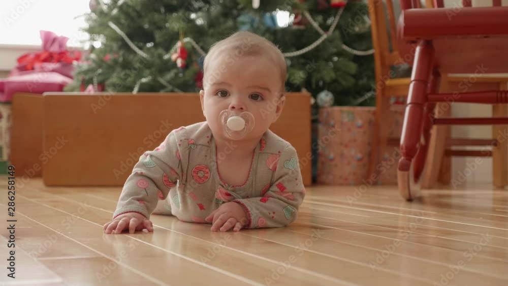 Slow motion shot of a little baby girl on a floor at Christmas Slow motion shot of a little baby girl on a floor at Christmas