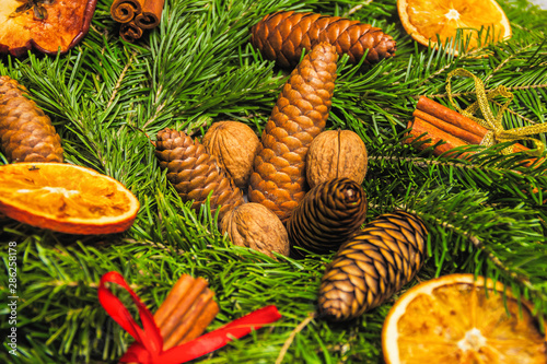 Christmas and New Year background. Pine branches, cinnamon sticks, dried slices of orange and walnuts. Christmas and New Year concept. Flat lay.