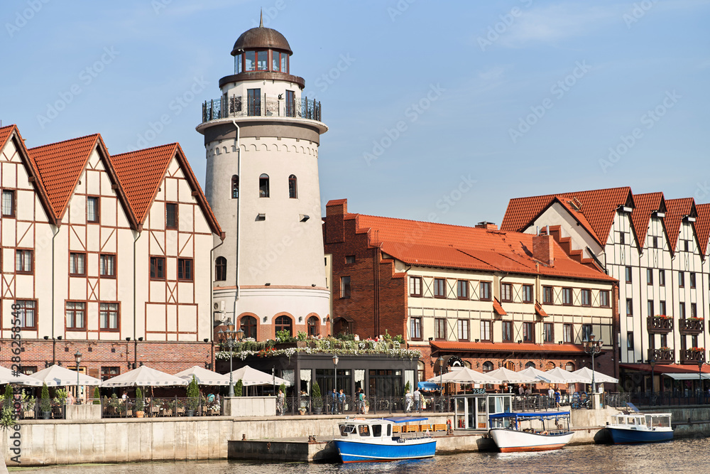 Kaliningrad, Russia - August 24, 2019: View of the Fish Village and lighthouse on the embankment of the Pregolya River.