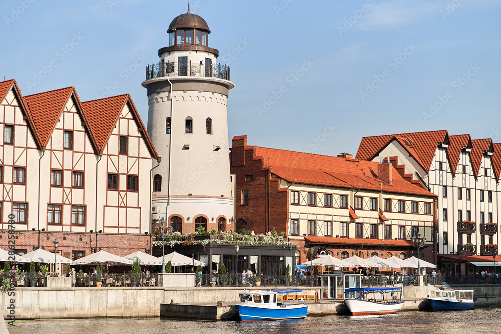 Kaliningrad, Russia - August 24, 2019: View of the Fish Village and lighthouse on the embankment of the Pregolya River.