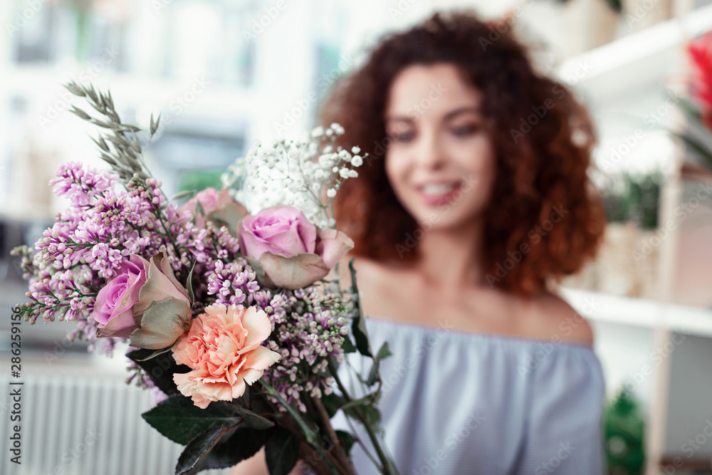 Smiling ginger woman looking on unusual gentle bouquet