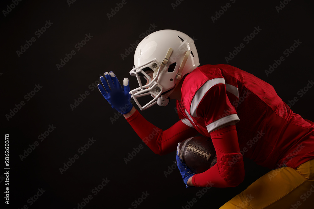 Photo of running sportswoman with rugby ball, in helmet