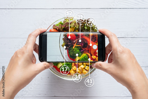 Calories counting and food control concept. woman using application on smartphone for scanning the amount of calories in the food before eat photo