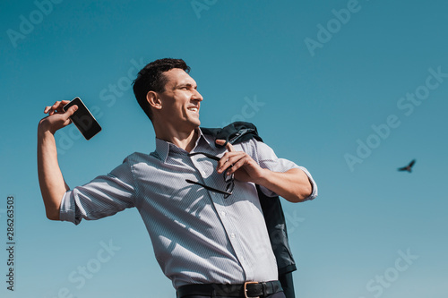 Office worker throwing his smartphone away while having a rest photo