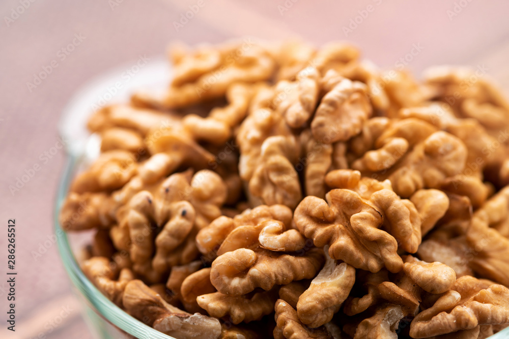 Studio photo of bowl with heap of peeled walnuts Studio photo of bowl with heap of peeled walnuts