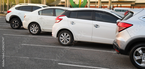Closeup of cars parking in outdoor parking lot  in twilight evening. © Amphon