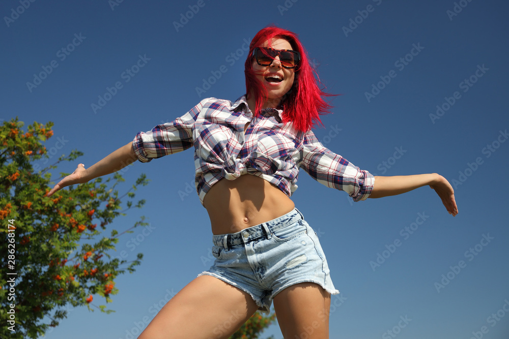 Obraz premium young happy girl in shirt and denim shorts