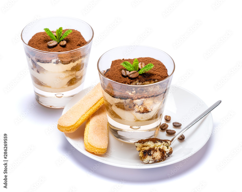Classic tiramisu dessert in a glass cup on the plate on white background with clipping path Classic tiramisu dessert in a glass cup on the plate on white background with clipping path